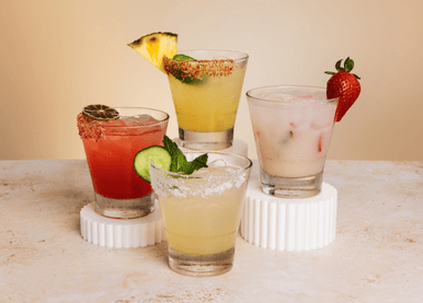 Pinstripes May margarita lineup featuring Garden Glow, Spring Fling, Desert Bloom, and Hot Pants on a dreamy background